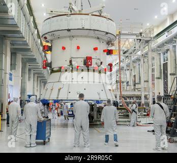 Artemis II SM passa alla cella rapida. Ingegneri e tecnici monitorano i progressi mentre l'European Service Module (ESM) per la missione Artemis II della NASA viene sollevato con una gru all'interno dell'alta baia del Neil A. Armstrong Operations and Checkout Building presso il Kennedy Space Center della NASA in Florida il 22 maggio 2023. Le squadre della NASA e della Lockheed Martin stanno preparando il modulo di servizio per il trasferimento nella cella VELOCE (assemblaggio finale e test del sistema) per i check-out finali prima che venga impilato con il modulo Orion Crew. La centrale elettrica che alimenterà e promuoverà Orion nello spazio, l'ESM verrà utilizzata per Artemis II Foto Stock