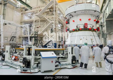 Artemis II SM passa alla cella rapida. Ingegneri e tecnici monitorano i progressi mentre l'European Service Module (ESM) per la missione Artemis II della NASA viene sollevato con una gru all'interno dell'alta baia del Neil A. Armstrong Operations and Checkout Building presso il Kennedy Space Center della NASA in Florida il 22 maggio 2023. Le squadre della NASA e della Lockheed Martin stanno preparando il modulo di servizio per il trasferimento nella cella VELOCE (assemblaggio finale e test del sistema) per i check-out finali prima che venga impilato con il modulo Orion Crew. La centrale elettrica che alimenterà e promuoverà Orion nello spazio, l'ESM verrà utilizzata per Artemis II Foto Stock