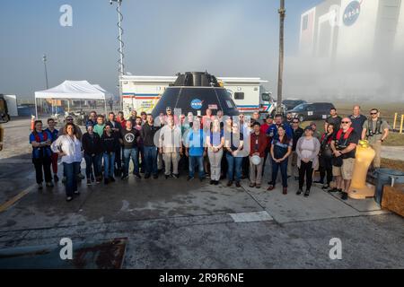 Test delle bacinelle a rotazione CMTA Artemis II. I membri della squadra di atterraggio e recupero Exploration Ground Systems (EGS) si riuniscono per una fotografia di gruppo davanti all'articolo di prova del Crew Module (CMTA) al bacino Turn nell'area del Launch Complex 39 al Kennedy Space Center della NASA in Florida il 1 febbraio 2023. Il CMTA viene utilizzato per praticare il recupero dopo lo splash down della navicella Orion per prepararsi alla missione con equipaggio Artemis II. EGS guida gli sforzi di recupero. Foto Stock