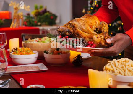 Cena di Natale con tacchino arrosto, cibo speciale a tavola nella sala da pranzo per la celebrazione della cena di Natale, Natale e Ringraziamento Foto Stock