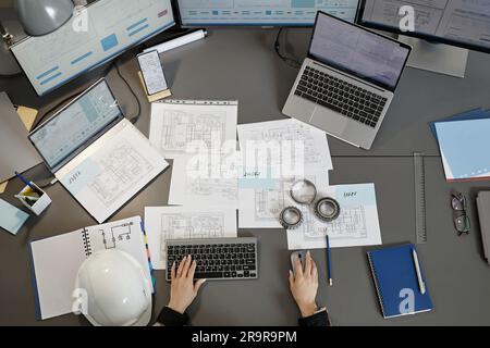 Vista dall'alto grandangolare sul luogo di lavoro degli ingegneri con progetti e piani sulla scrivania del computer, spazio di copia Foto Stock