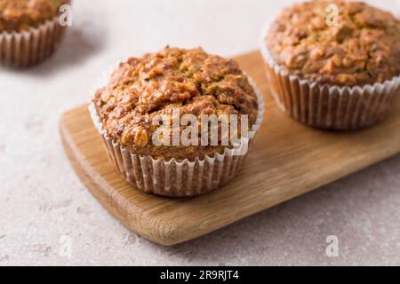 Muffin di zucca appena sfornati fatti in casa con farinata d'avena e noci su sfondo beige Foto Stock