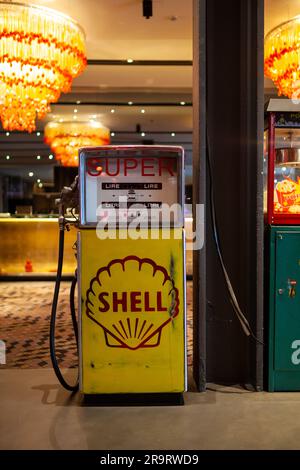 Milano, Italia - 21 aprile 2023: Pompa a benzina o benzina d'epoca gialla con tubo nero e logo del marchio Shell esposto durante il design milanese Foto Stock
