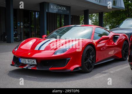 Pärnu, ESTONIA - 18 giugno 2023: Ferrari rossa 488 pista con strisce bianche e blu parcheggiata a Pärnu. Potente cicatrice sportiva rossa. Foto Stock