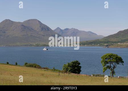 Guardando il Sound of Raasay verso Glamaig & Sgurr Nan Gillean su Skye in una soleggiata mattinata estiva, con il traghetto CalMac diretto a Sconser Foto Stock