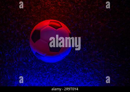 Pallone da calcio con illuminazione al neon su fondo erboso. Poster a tema sportivo orizzontale, biglietti di auguri, intestazioni, sito Web e app Foto Stock