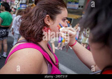 Madrid, Spagna. 28 giugno 2023. Una donna dipinge la guancia con la bandiera dell'orgoglio durante la marcia critica dell'orgoglio per le strade di Madrid. Diversi gruppi che compongono la Critical Pride Platform di Madrid hanno organizzato una manifestazione alternativa contro gli eventi ufficiali del World Pride e cercano di rivendicare i diritti del collettivo LGTBIQ. Credito: SOPA Images Limited/Alamy Live News Foto Stock