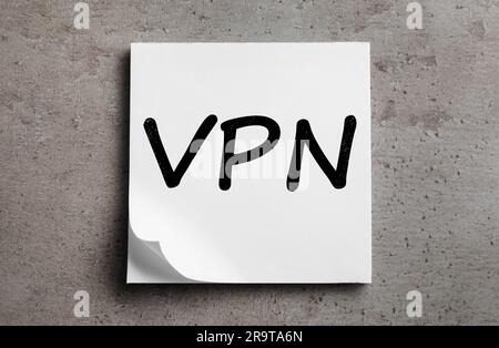 Foglio di carta con acronimo VPN (Virtual Private Network) su tabella grigia, vista dall'alto Foto Stock