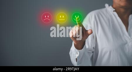 Gli uomini d'affari stanno toccando lo schermo virtuale sull'icona Happy Smiley Face per offrire soddisfazione nel servizio. Servizio clienti e concetto di soddisfazione, Foto Stock