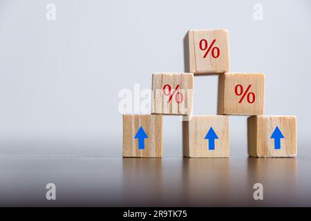 Closeup cubetti di legno con simbolo percentuale, percentuale e frecce crescenti verso l'alto su cubetti di legno. Aumento o prezzo dei tassi ipotecari di interesse finanziario Foto Stock