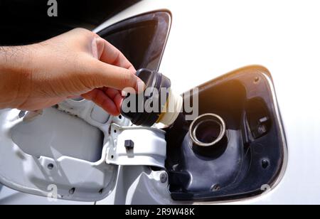 Primo piano della mano di un uomo che apre il serbatoio del gas di un'auto per il rifornimento. Foto Stock