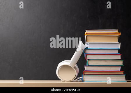 Pila di libri e cuffie su un tavolo con spazio per la copia Foto Stock
