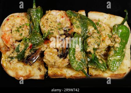 gamberoni saltati con pepe di padron in salsa di burro e pane croccante Foto Stock