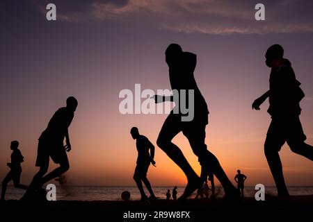 Giocatori di calcio al tramonto su una spiaggia a Dakar, in Senegal Foto Stock