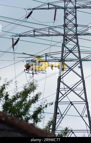 Elicottero Airbus giallo vicino a linee elettriche troppo alte Foto Stock