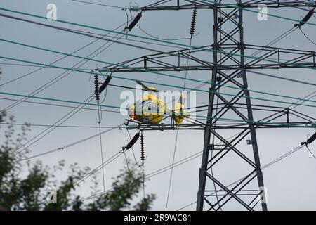 Elicottero Airbus giallo vicino a linee elettriche troppo alte Foto Stock