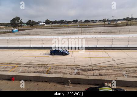 Blue Porsche Cayman GT4 che corre al Sebring International Raceway attraverso la curva 15 Foto Stock