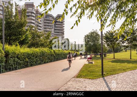 People walking at sunset in summer, in the park of Milano CityLife district, Milano, Italy. Foto Stock