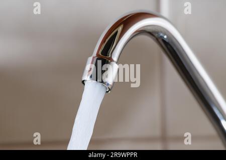 L'immagine orizzontale di un rubinetto con acqua fluente fortemente sotto pressione elevata Foto Stock