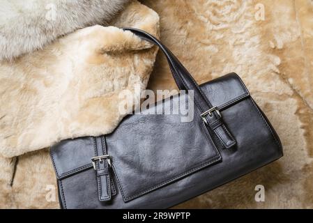 Una borsa in pelle nera con calda pelle di pecora bionda, volpe blu e pellicce di visone rosso zibellino Foto Stock