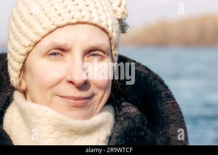 Ritratto di una donna adulta che indossa una pelliccia e un cappello di lana in inverno Foto Stock