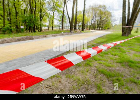 Rosso e bianco nastro striato che definisce il confine di una zona pericolosa di lavori di costruzione in corso Foto Stock
