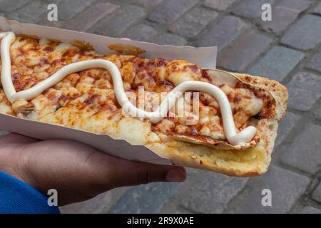 scopri il gusto della polonia con un appetitoso zapiekanka, un panino caldo su mezza baguette, abbondantemente riempito con vari condimenti, che offre una Foto Stock