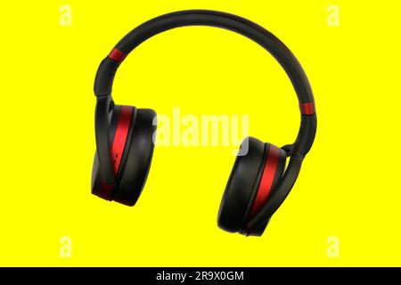 Cuffia stereo wireless. Cuffie cordless nere e rosse. Auricolari isolati su sfondo giallo con percorso di ritaglio. Immagine macro orizzontale, Chiudi- Foto Stock