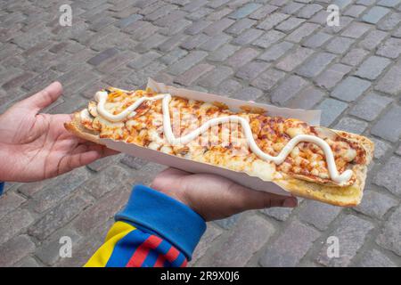 scopri il gusto della polonia con un appetitoso zapiekanka, un panino caldo su mezza baguette, abbondantemente riempito con vari condimenti, che offre una Foto Stock