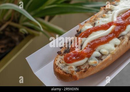 scopri il gusto della polonia con un appetitoso zapiekanka, un panino caldo su mezza baguette, abbondantemente riempito con vari condimenti, che offre una Foto Stock