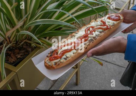 scopri il gusto della polonia con un appetitoso zapiekanka, un panino caldo su mezza baguette, abbondantemente riempito con vari condimenti, che offre una Foto Stock