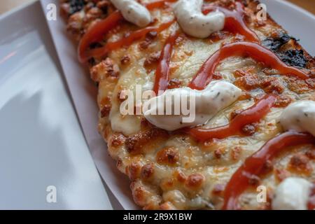 scopri il gusto della polonia con un appetitoso zapiekanka, un panino caldo su mezza baguette, abbondantemente riempito con vari condimenti, che offre una Foto Stock