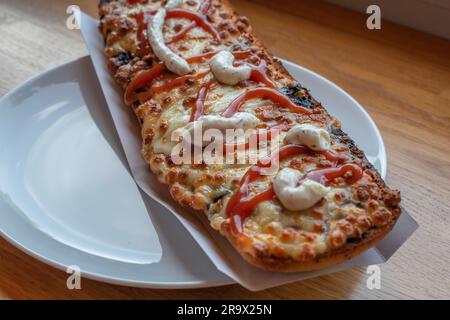 scopri il gusto della polonia con un appetitoso zapiekanka, un panino caldo su mezza baguette, abbondantemente riempito con vari condimenti, che offre una Foto Stock