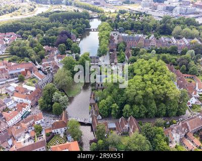 Vista aerea del beghinaggio principesco Ten Wijngaerde, del parco acquatico minnewater e del ponte. È l'unico beghinaggio conservato nella città belga di Brug Foto Stock