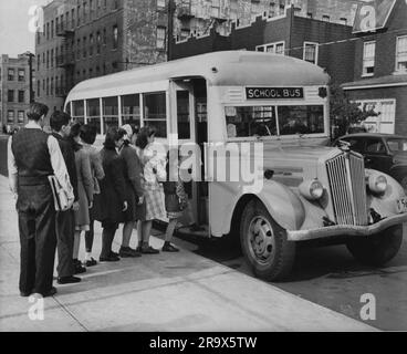 Immagine dei bambini del centro città in fila che tengono i libri scolastici per salire sullo scuolabus. Tutto vestito in modo intelligente Foto Stock