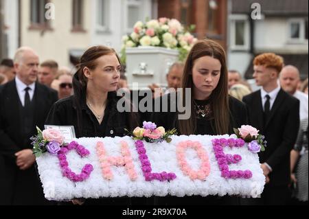 Le sorelle di Chloe Mitchell, Kirsty (a sinistra) e Nadine, portano una corona davanti alla sua bara mentre viene portata lungo Larne Street, a Ballymena. Data foto: Giovedì 29 giugno 2023. Foto Stock