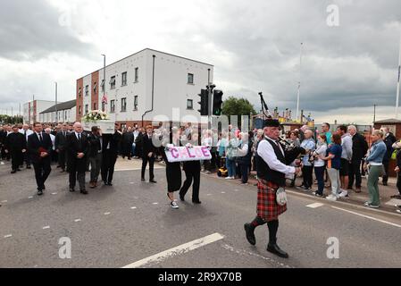 Le sorelle di Chloe Mitchell, Kirsty (a sinistra) e Nadine, portano una corona davanti alla sua bara mentre viene portata lungo Larne Street, a Ballymena. Data foto: Giovedì 29 giugno 2023. Foto Stock