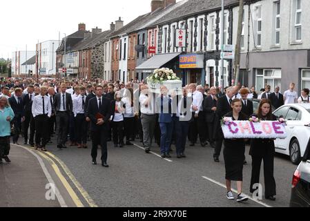 Le sorelle di Chloe Mitchell, Kirsty (a sinistra) e Nadine, portano una corona davanti alla sua bara mentre viene portata lungo Larne Street, a Ballymena. Data foto: Giovedì 29 giugno 2023. Foto Stock