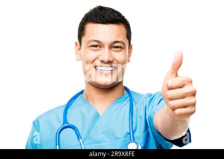 Pollice su, sorriso e ritratto di un medico maschio in studio per una consultazione medica con fiducia. Assistenza sanitaria asiatica felice, professionale e giovane Foto Stock