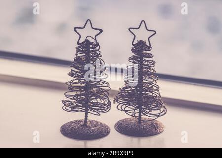 Due piccoli decorativo di alberi di Natale con glitter e stelle in un ornamento a Xmas Foto Stock