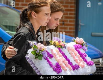 Le sorelle di Chloe Mitchell, Kirstie (a sinistra) e Nadine, portano una corona davanti alla sua bara mentre viene portata lungo Larne Street, a Ballymena. Data foto: Giovedì 29 giugno 2023. Foto Stock