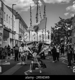 Una processione in bianco e nero a Londra per commemorare Windrush 75 a Brixton. Foto Stock