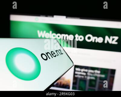 Smartphone con il logo della società One New Zealand Group Limited (One NZ) sullo schermo davanti al sito Web. Mettere a fuoco il display centrale sinistro del telefono. Foto Stock