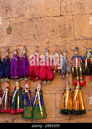 Marionette colorate del Rajasthan appese nel negozio. Marionette in legno fatte a mano. Foto Stock