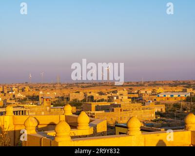 Jaisalmer, India - 24 dicembre 2022: La città dorata dell'India con mulini a vento, Jaisalmer, si erge su una cresta di arenaria giallastra Foto Stock