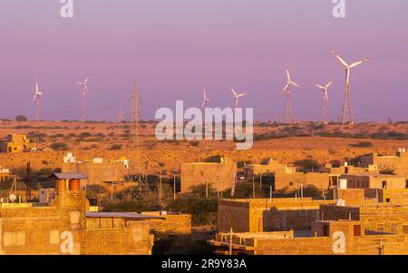 Jaisalmer, India - 24 dicembre 2022: La città dorata dell'India con mulini a vento, Jaisalmer, si erge su una cresta di arenaria giallastra Foto Stock