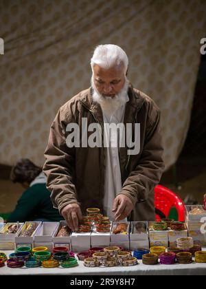 Udaipur, India - 29 dicembre 2022: Venditore musulmano non identificato che vende bene al mercato locale di Udaipur chiamato Haathipol. Foto Stock