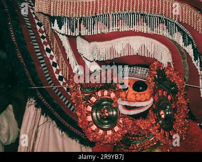 theyam, una popolare forma d'arte di culto praticata in kerala eseguita da un artista in costume tradizionale durante il festival del tempio come rituale Foto Stock