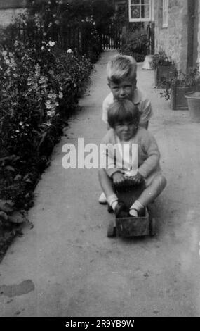 Un ragazzo che spinge una ragazza su un carrello. Surrey, c1930. Si tratta di una fotografia tratta da un album di scatti, durante l'occupazione della Palestina da parte dell'esercito britannico, con foto provenienti dalla Palestina e dal Regno Unito, tra cui devil's Jump vicino a Churt nel Surrey e devil's Punch Bowl. L'addestramento sembra essere a Hursley Camp, vicino a Winchester. La Gran Bretagna amministrò la Palestina per conto della società delle Nazioni tra il 1920 e il 1948, un periodo denominato "mandato britannico”. Foto Stock