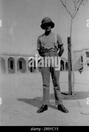 Un soldato in uniforme a Malta, con caserme sullo sfondo. Foto da un album di famiglia di immagini scattate principalmente nel Regno Unito, intorno al 1929. La famiglia viveva a Witley, nel Surrey, e aveva alcuni legami con l'esercito. Foto Stock